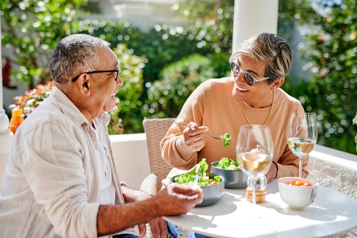 senior couple enjoying salads outside on a sunny day