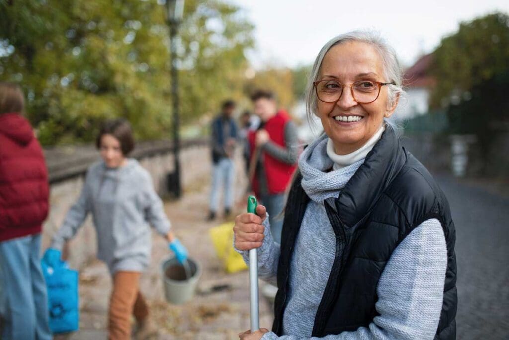 a senior woman volunteering to clean up a park