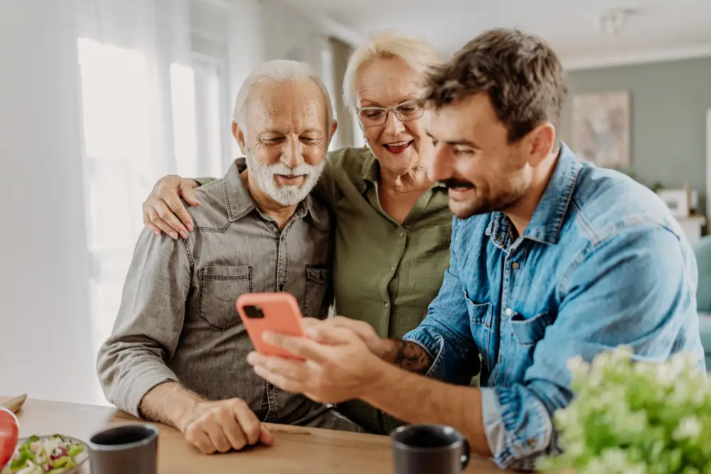 man showing his senior parents something on his smart phone